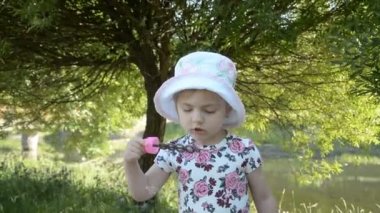 Sevimli küçük kız yaz günü hd görüntüleri bir sabun kabarcıkları üfleme