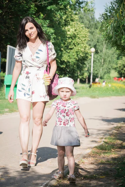 Concept familial heureux belle mère et petite fille marchent dans le parc de la ville en été — Photo