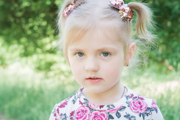Portret van een klein mooi meisje in een stadspark — Stockfoto