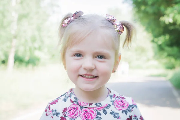 Portret van een klein mooi meisje in een stadspark — Stockfoto