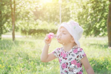 Küçük kız sabun köpüğü üflüyor
