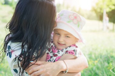 Anne parkta kızını kucaklıyor.