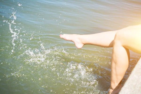 Piernas femeninas en el agua del río — Foto de Stock