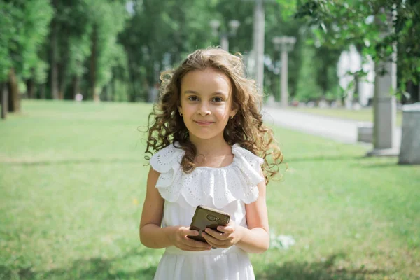 Bellissimo bambino, bambina con un telefono cellulare in mano — Foto Stock