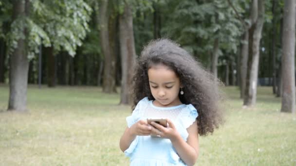 若い女の子は 屋外でスマートフォンを使用しています ライフスタイルの概念 — ストック動画