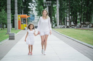 Anne ve kızı şehir parkında yürümek