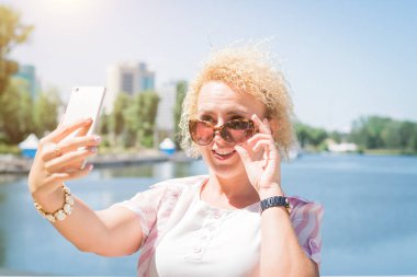 Sevimli gülümseyen genç Kafkas genç kız açık havada selfie çekerken