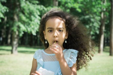 küçük kız çocuk bir şehir parkında fast food kızarmış patates yiyor