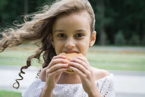 Carino bambina mangiare fast food hamburger — Foto Stock