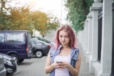 Parkta akıllı telefona mesaj alan kız