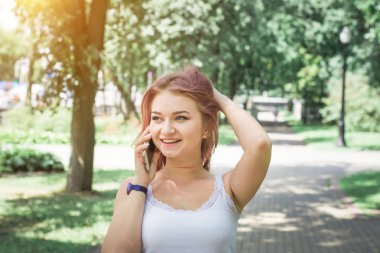 Telefonda konuşurken pembe saçlı genç hipster kadın