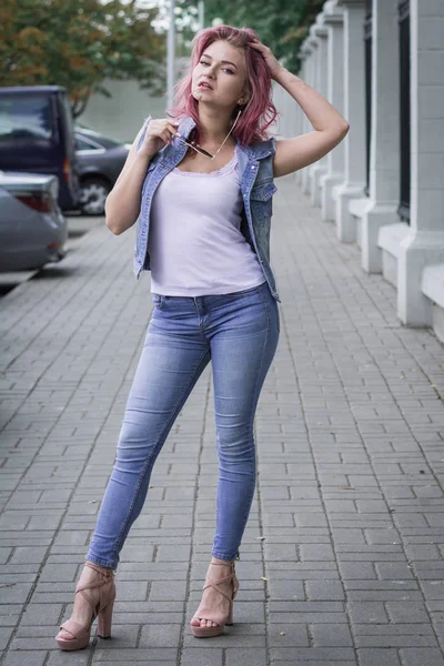 Snygg ung tjej elev i jeans går genom stadens gator — Stockfoto