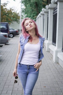 Kot pantolon şık genç kız öğrenci şehir sokaklarında yürüyor