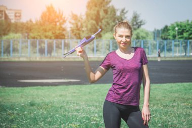 Bir kadın doğada oyuncak bir uçak fırlatıyor.