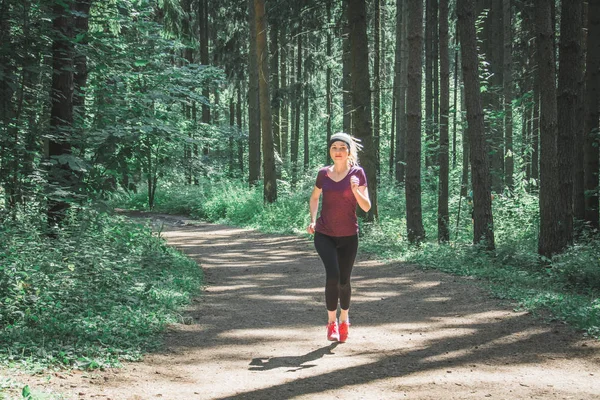 Unga fitness kvinna kör på morgonen skogsstig — Stockfoto