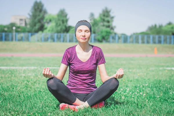 Young woman practicing morning meditation in nature at the park
