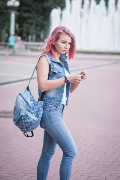 Attractive hipster student with stylish backpack walking in urban setting near promotional background — Stock Photo, Image