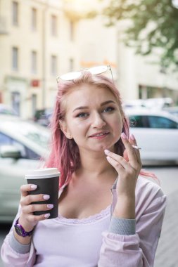 Sigara ve içme kahvesi ile güzel genç kadın