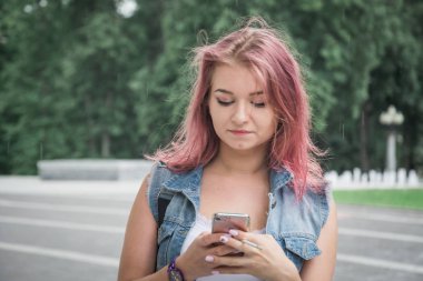Hipster Girl arkadaşları ile telefonda iletişim kurar ve bir sigara içer