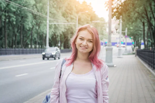 Hipster chica con el pelo rojo sonriendo poses para un fotógrafo —  Fotos de Stock