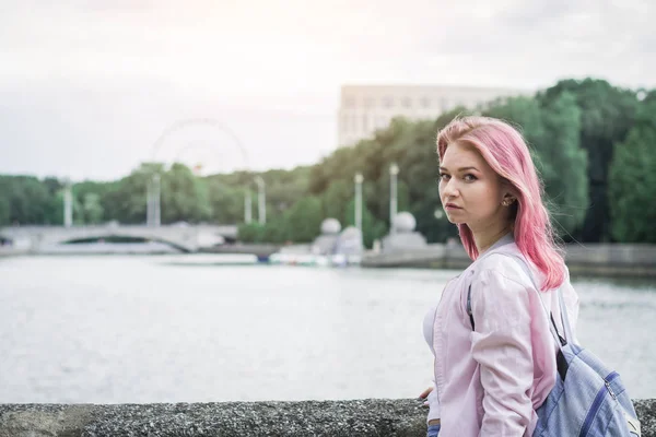 都市の川に立ちながらバックパックを持つ若い女性 — ストック写真