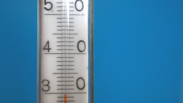 Das Thermometer auf blauem Hintergrund — Stockvideo