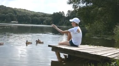 beyaz bir t-shirt güzel genç kız bir şehir gölet kuşlar besler