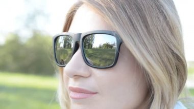 Siyah güneş gözlüğü ve gülümseme ile Oldukça çekici sarışın kadın