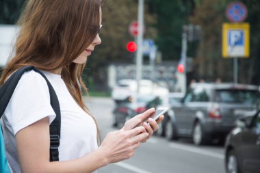 Kırmızı sırt çantası ve şehirde yürüyüş kitap ile Neşeli çekici genç kadın