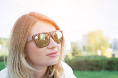 Güneş gözlüğü ve sonbahar giysileri yanlara açık poz mutlu sarışın kadının yakın görüntü