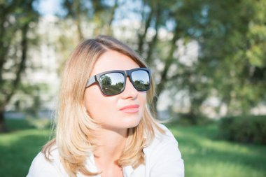 Güneş gözlüğü ve sonbahar giysileri yanlara açık poz mutlu sarışın kadının yakın görüntü