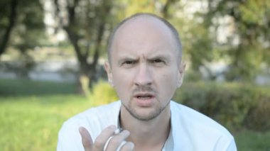 kel adam yaz parkı portre sigara içiyor
