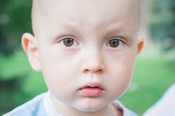 Outdoor close up portrait of little boy in a hat