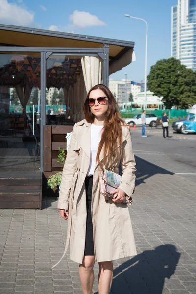 Mujer joven y elegante camina por las calles de la ciudad de su ciudad en un día soleado de otoño — Foto de Stock