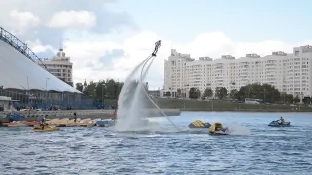 Minsk, Beyaz Rusya - 14 Eylül 2019: Flyboarder Uçan Minsk şehir günü tatilinde Gökyüzü arka plan ve şehir binası üzerinde hileler yapıyor — Stok video