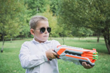 Oyuncak tabancalı sekiz yaşındaki güzel çocuk.