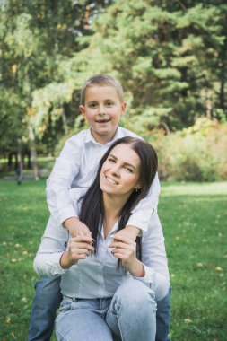 Sekiz yaşındaki oğlu çim parkta anne kucaklıyor