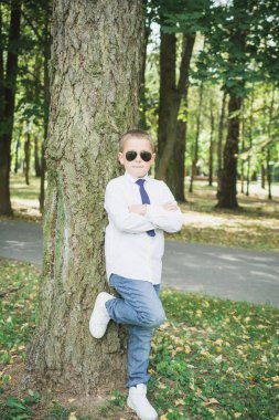 Güneş gözlüğü yakışıklı sekiz yaşındaki çocuk portresi