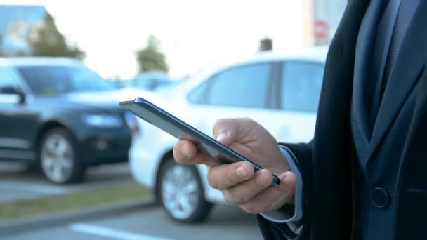 Concepto de negocio, manos de un hombre de negocios en un aparcamiento de coches escribir sms en el teléfono — Vídeos de Stock