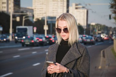 Taksi yolculuğu için telefon uygulamasını kullanan kadın, seyahat sırasında yol tarifi ve rehber bulmak için telefon uygulamasını kullanıyor