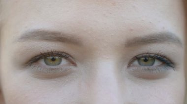 Gözleri kameraya bakan genç güzel beyaz kadın yüzünün yakın çekim portresi