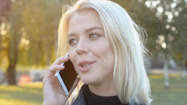 Portret van mooie gelukkige jonge vrouw is praten met haar vriend op de smartphone — Stockvideo