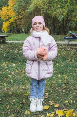 Sonbahar parkında beş yaşında güzel bir kız.