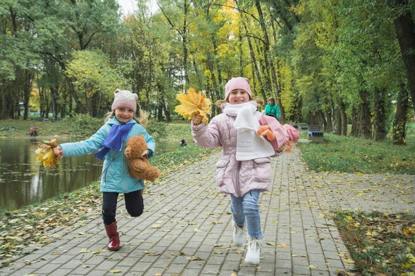 Két ötéves nővér fut az őszi parkban. — Stock Fotó