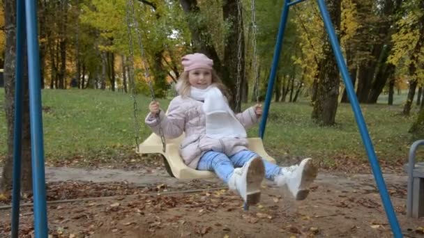 Little girl five years old playing with swings — Stock Video