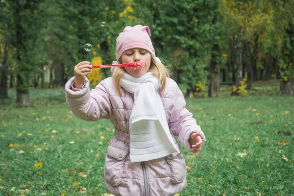 Милая девушка играет с мыльными пузырями — стоковое фото