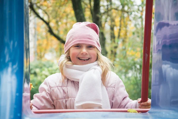 Aire de jeux et petite fille de cinq ans dans le parc d'automne — Photo