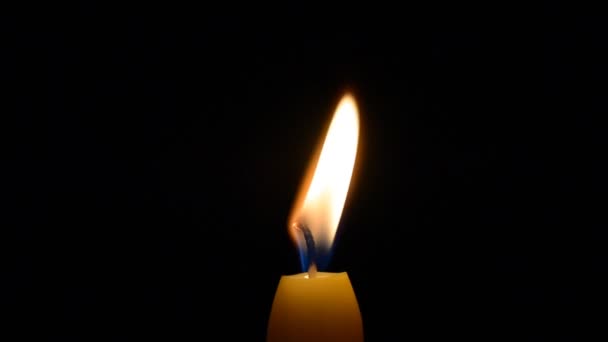 Nahaufnahme Kerzenflamme auf schwarz — Stockvideo