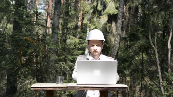 Ingeniero que trabaja en un ordenador portátil en el bosque — Vídeos de Stock