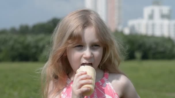 Caucasienne petite fille de cinq ans manger de la crème glacée dans un portrait de parc d'été — Video